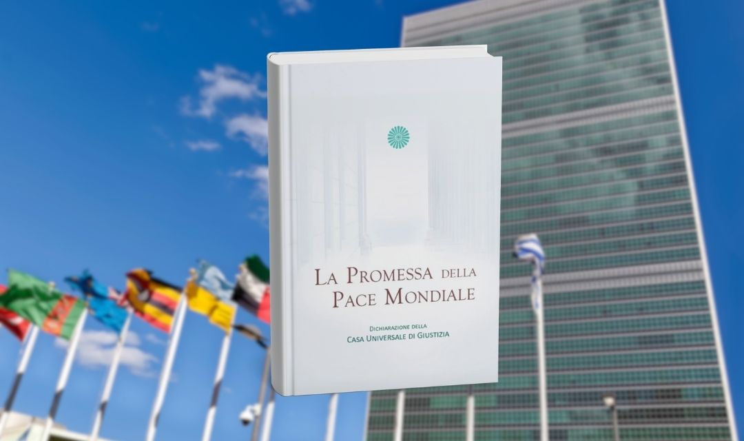 Copertina del libro Bah&aacute;&rsquo;&iacute; &ldquo;La Promessa della Pace Mondiale&rdquo; davanti al Palazzo di Vetro delle Nazioni Unite e bandiere internazionali.
